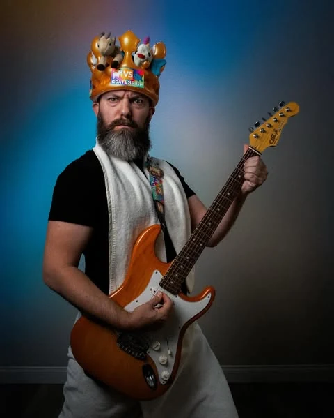 GoatVsFish in a crown of toy animals playing electric guitar